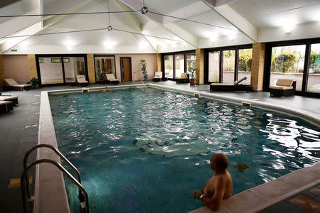 A resident relaxes in a swimming pool at The Thatchers Holiday Village in Modbury Devon, Britain April 12, 2017. REUTERS/Dylan Martinez