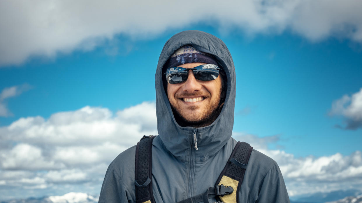  hiker in the alpine with puffy clouds in the background 