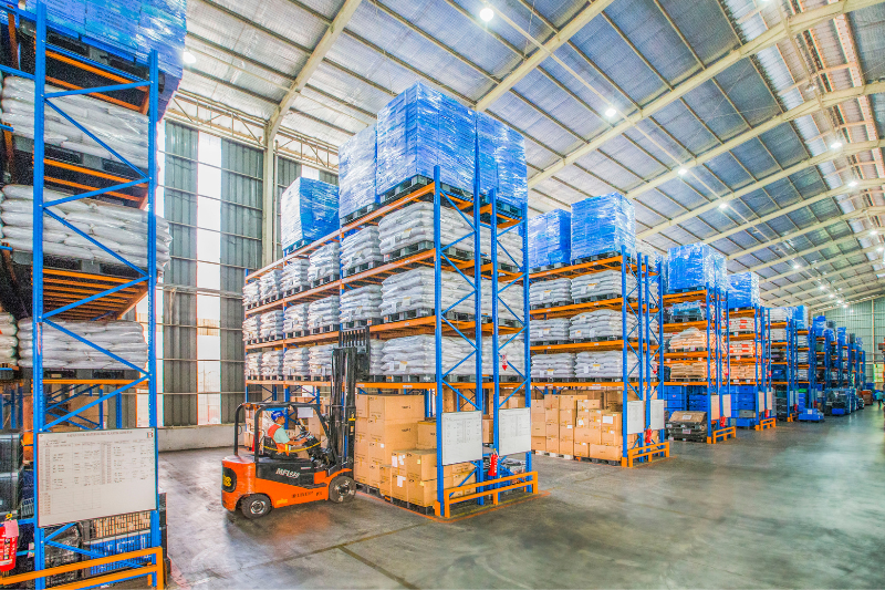 Forklift Among Rows of Shelves