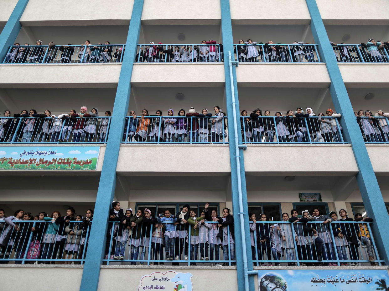 Palestinian schoolgirls pose for a group picture outside their classrooms at a school belonging to the United Nations Relief and Works Agency for Palestine Refugees (UNRWA) in Gaza City on 22 January 2018: Getty