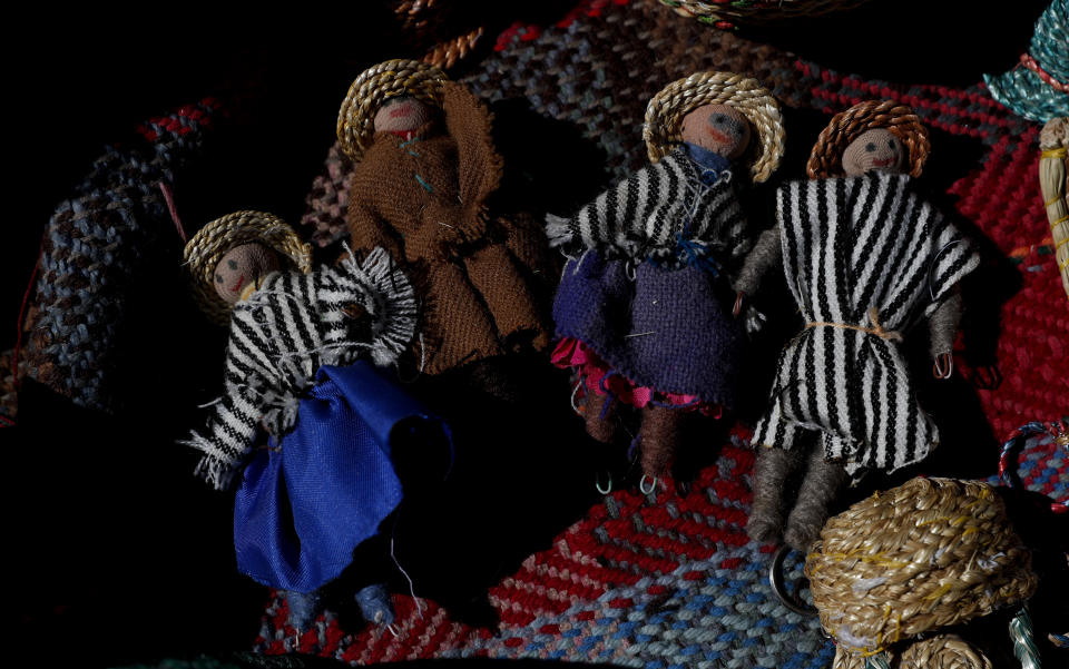 Handmade dolls depicting an Uru family lay on a woven textile in the home of Evarista Flores, in the Urus del Lago Poopo indigenous community, in Punaca, Bolivia, Monday, May 24, 2021. For many generations, the Uru — "people of the water" — would build a sort of family island of reeds when they married and would survive on what they could harvest from the broad, shallow lake in the highlands of southwestern Bolivia. (AP Photo/Juan Karita)