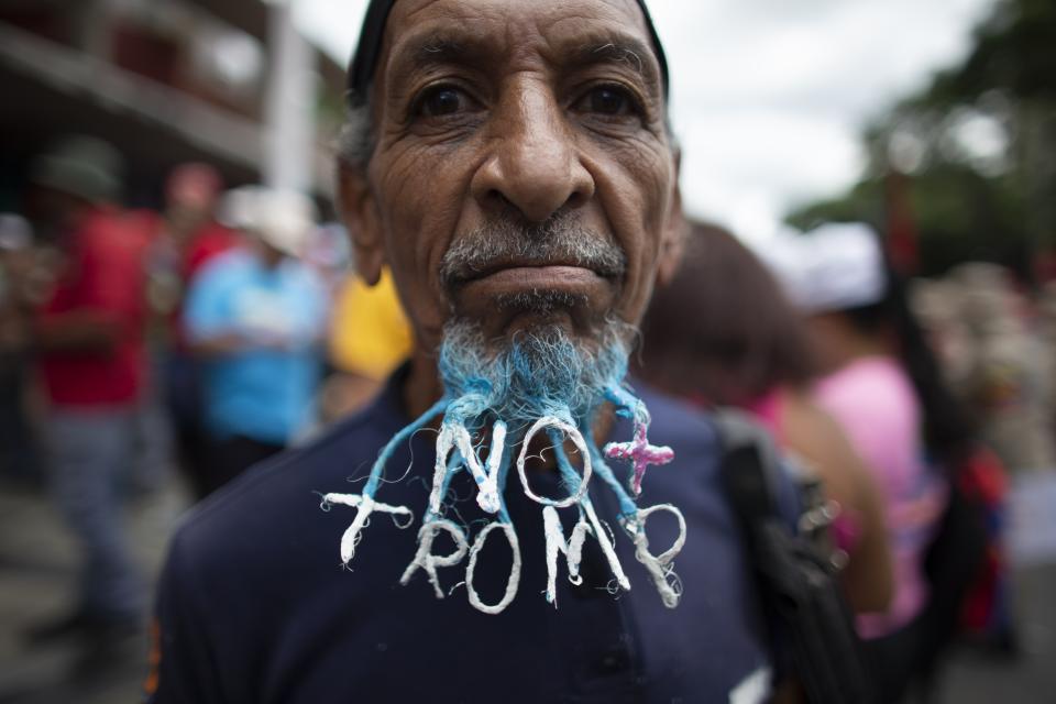 A supporter of President Nicolas Maduro dons a beard woven into a message that reads in Spanish; "No more Trump" during an anti-imperialist rally in Caracas, Venezuela, Saturday, Aug. 31, 2019. U.S.-based Mastercard suspended its services to two Venezuelan banks under sanctions aimed at forcing Maduro from power in the crisis-stricken South American nation. (AP Photo/Ariana Cubillos)