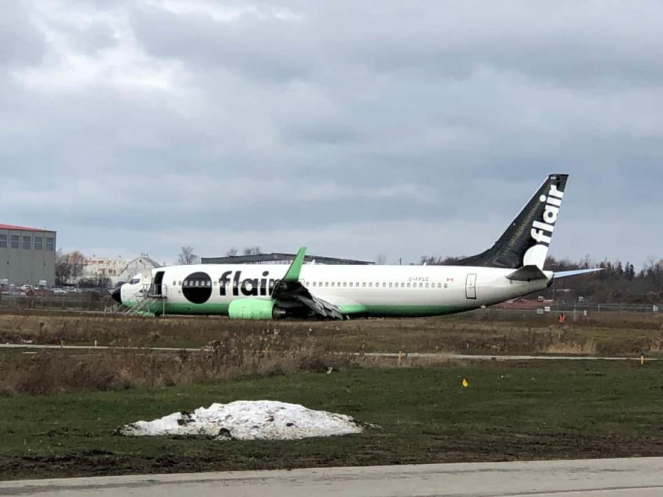 Flight F8 501 from Vancouver overran the runway at Waterloo Region International Airport on Friday morning. There were no injuries reported by passengers or crew, but damage to a wing was visible. (Carmen Groleau/CBC - image credit)