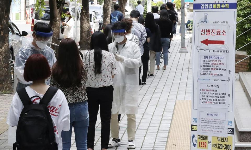 People wait in line to be tested at a coronavirus screening station in Bucheon, South Korea