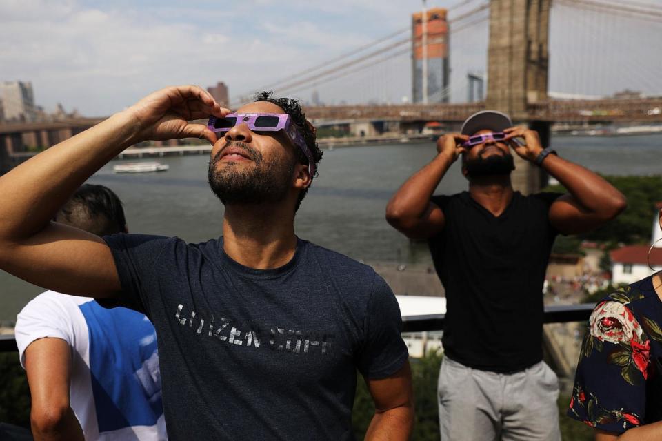 PHOTO: People watch a partial solar eclipse from the roof deck at the 1 Hotel Brooklyn Bridge on Aug. 21, 2017 in the Brooklyn borough of New York City.  (Spencer Platt/Getty Images, FILE)