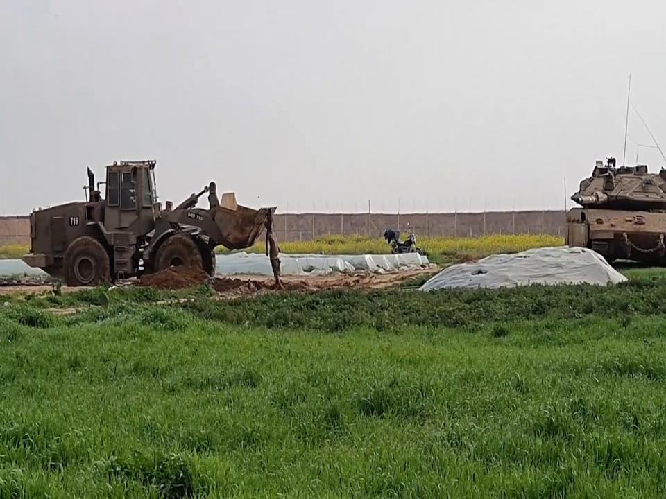 In this frame grab from video, an Israeli military vehicle removes the body of a Palestinian after he was shot and killed by soldiers, along the Gaza-Israel border, Sunday, Feb. 23, 2020. The Israeli military said it shot two Palestinian militants trying to place an explosive device along the border with Gaza, and Palestinian official said one of them was killed. The Hamas militant group accused Israel of abusing the corpse. The incident comes amid a relative lull along the security fence separating Israel from Gaza. (AP Photo)