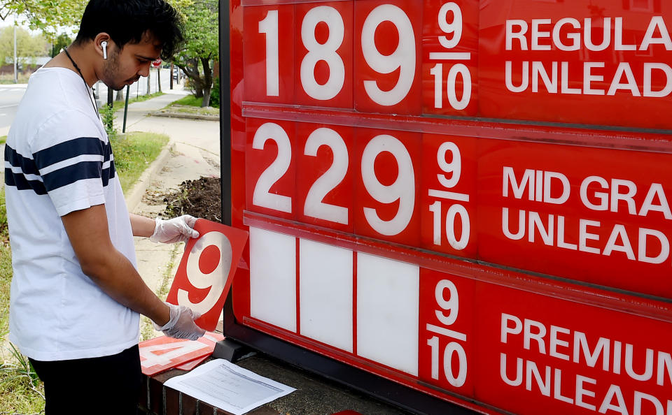 An employee of a gas station adjusts gasoline pump prices as they continue to fall with the oil market in turmoil on April 21, 2020, in Arlington, Virginia.(Photo by Olivier DOULIERY / AFP) 