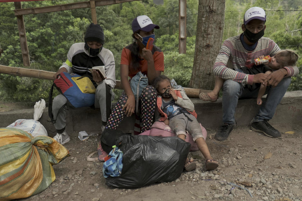 Venezuelan migrants rest as they walk away from the Venezuelan border toward Pamplona, Colombia, Wednesday, Oct. 7, 2020. Colombian immigration officials expect 200,000 Venezuelans to enter the country in the months ahead, enticed by the prospects of earning higher wages and sending money back to Venezuela to feed their families. (AP Photo/Ferley Ospina)