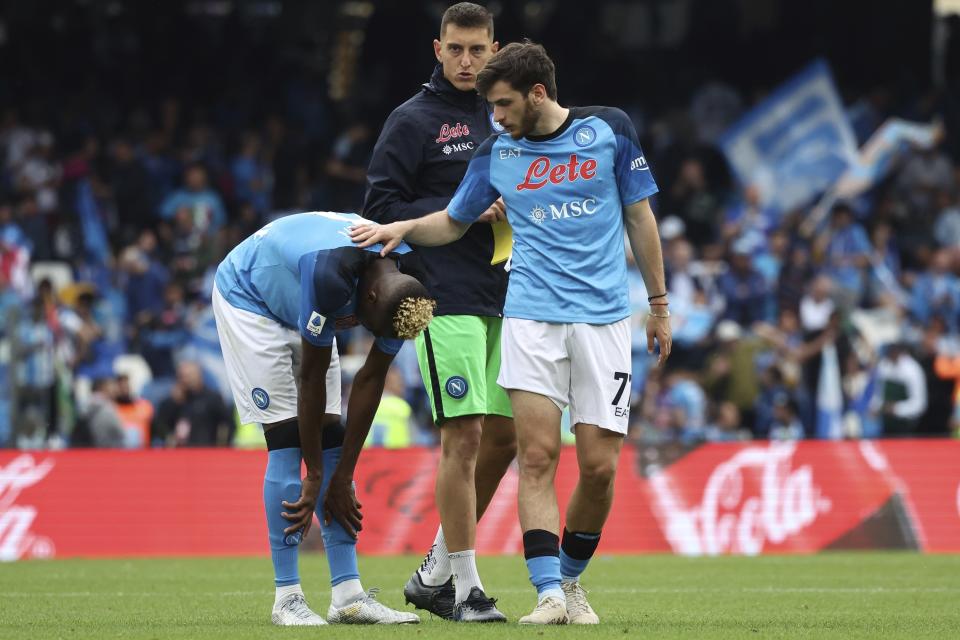 Napoli's Victor Osimhen, left, is consoled by Khvicha Kvaratskhelia after the Serie A soccer match between Napoli and Salernitana, at the Diego Armando Maradona stadium in Naples, Italy, Sunday, April 30, 2023. The match ended in a 1-1 draw. (Alessandro Garofalo/LaPresse via AP)