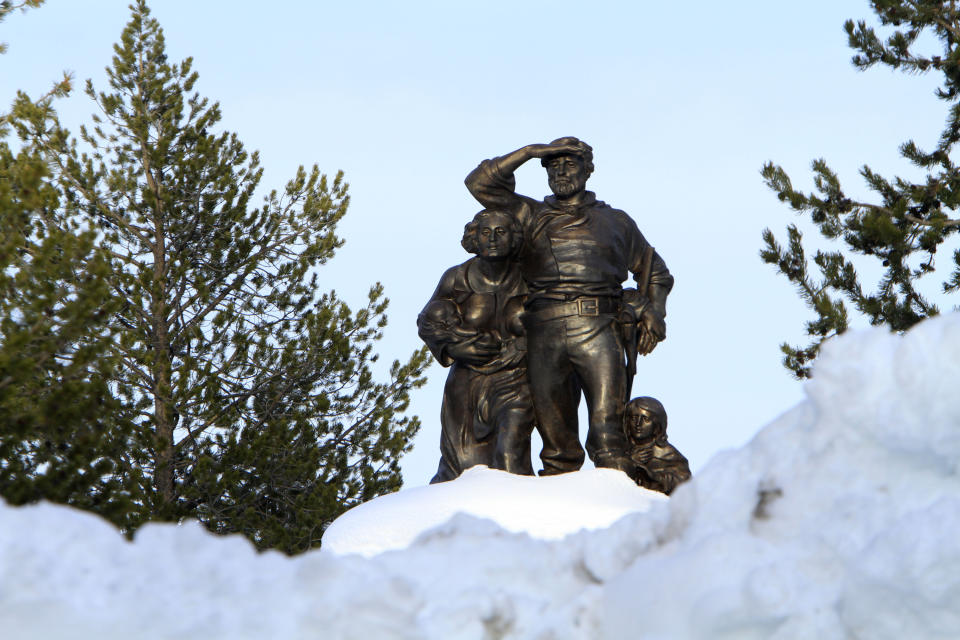 FILE - The Pioneer Memorial, dedicated to the Donner Party, is seen behind snow cleared from the parking lot at the Donner Memorial State Park at Truckee, Calif., on March 28, 2011. The snow depth reaches up to half the height of the 22-foot tall shaft the statues are placed on. A relentless 2022-23 winter at Lake Tahoe has now etched its way into the history books as the Sierra's second-snowiest on record. (AP Photo/Rich Pedroncelli, File)