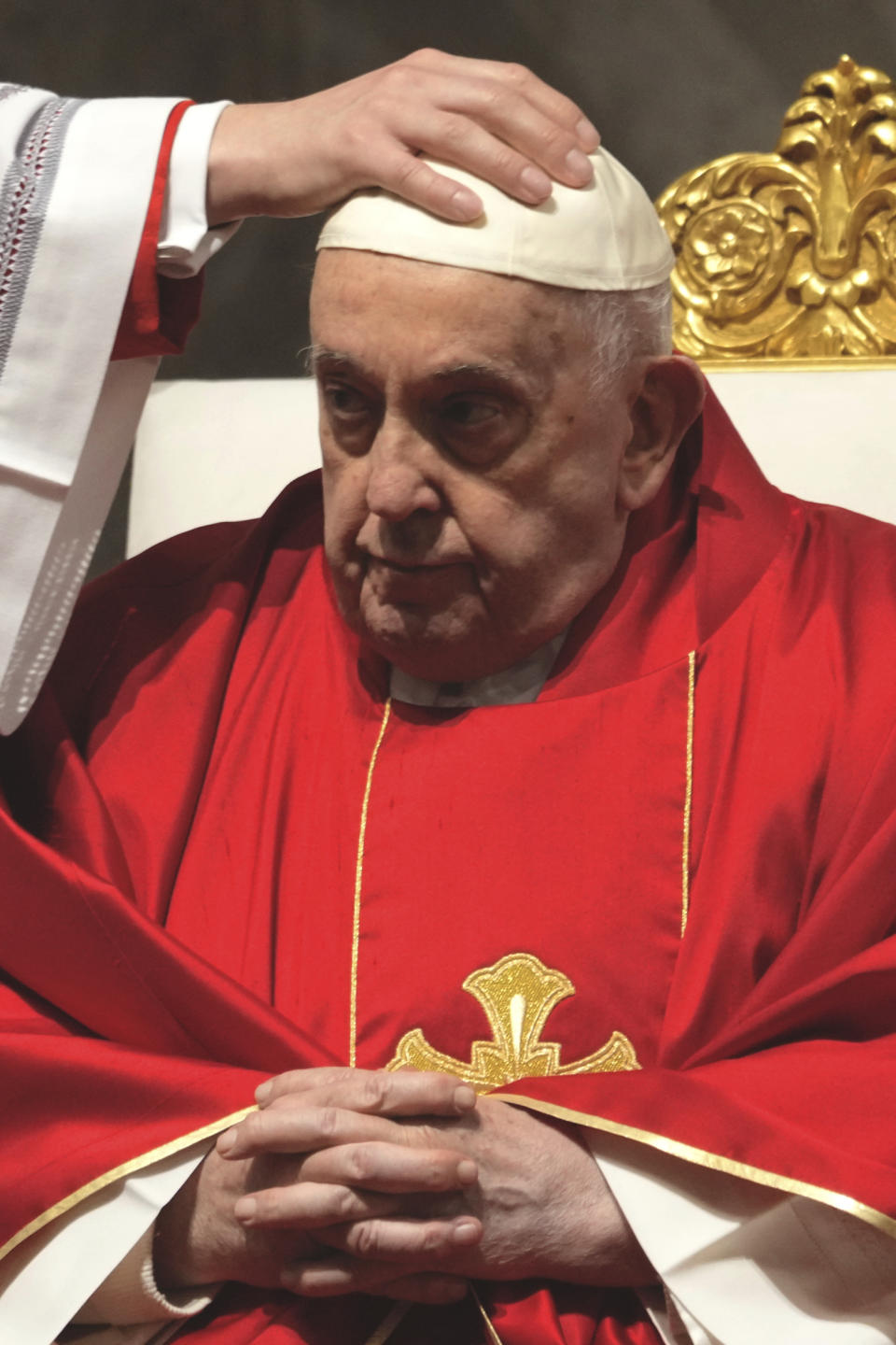 Monsignor Krzysztof Marcjanowicz puts the skull cap on Pope Francis during the Liturgy of the passion on Good Friday in St. Peter's Basilica at The Vatican, Friday, Mar. 29, 2024. (AP Photo/Domenico Stinellis)