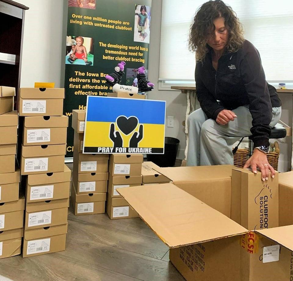 Julie Becker of Clubfoot Solutions packs boxes containing the Iowa Brace in the home office used by the nonprofit in Bettendorf. The organization’s next shipment to Ukraine will include a special stuffed bear for kids, wearing a tiny Iowa Brace in the colors of the Ukrainian flag.