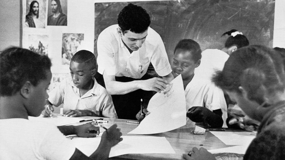 In this Aug. 23, 1964 file photo, Bruce Solomon, of the Brooklyn borough of New York, teaches a class for young Black students about arts, African American history and rights at a "Freedom School" in Jackson, Miss. Solomon was one of hundreds of volunteers in the “Mississippi Summer Project.” The classes throughout the state were set up by the volunteer workers in churches, homes and other buildings to encourage African Americans to register to vote during the long hot summer. - BH/AP