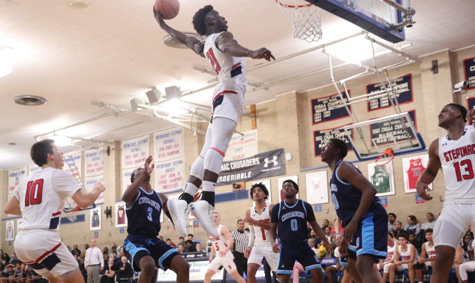 Stepinac's Adrian Griffin Jr. (21) stuffs a rebound during their 81-69 win over Monsignor Scanlan at Stepinac High School in White Plains on Friday, December 6, 2019.