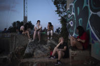 In this July 25, 2020 file photo, people gather outdoors at dusk on a viewpoint in Barcelona, Spain. The average age of a virus patient in Spain has fallen from 63 in the spring to 45 now and "the pressure on the health system is low," said Spanish Health Minister Salvador Illa. Since the virus takes a heavier toll on the elderly, younger coronavirus patients means more who have milder symptoms. (AP Photo/Felipe Dana)