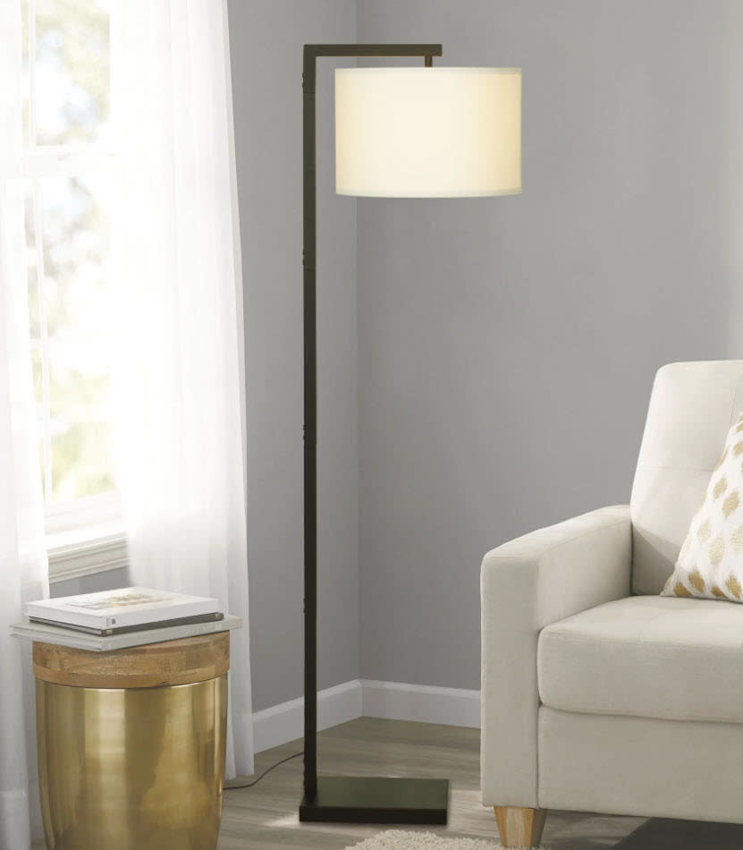 standing lamp with black base and white shade next to couch