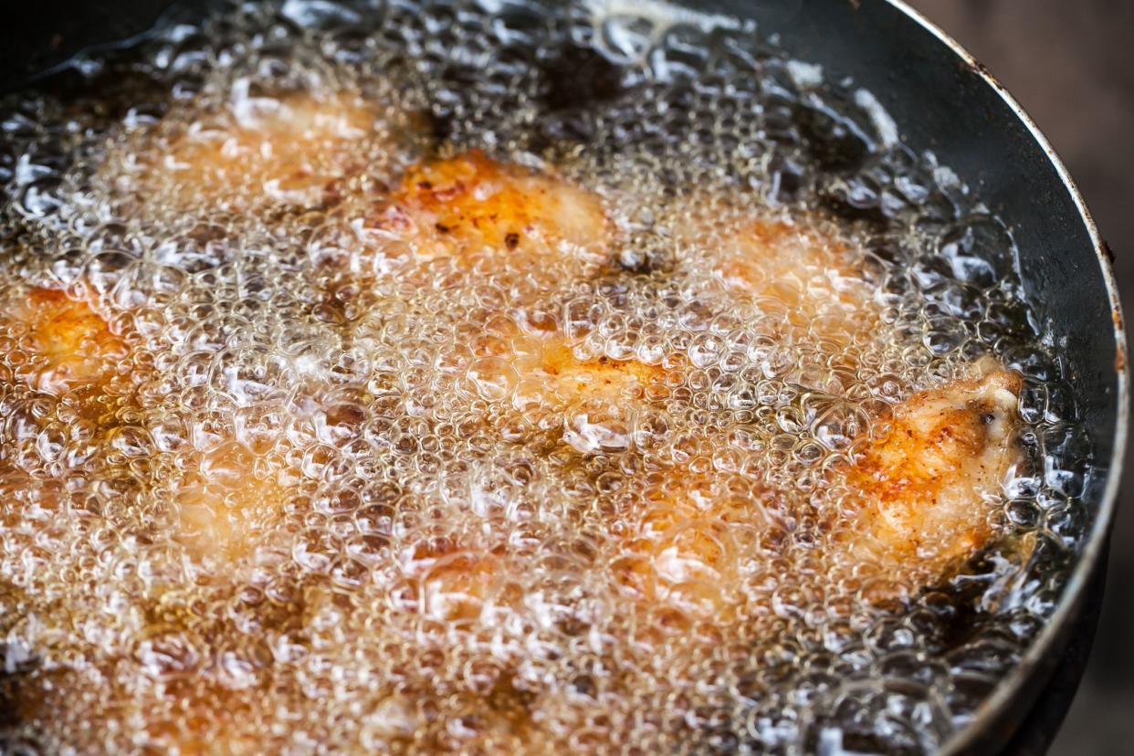 chicken frying in deep pan