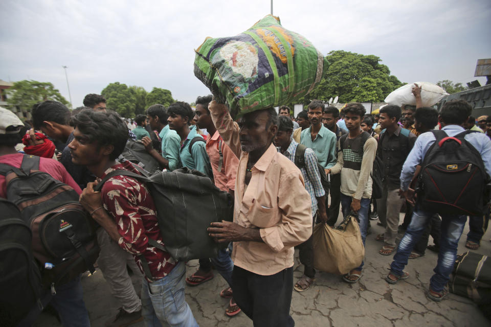 Indian migrant laborers carry their luggage and prepare to leave the region, at a railway station in Jammu, India, Wednesday, Aug. 7, 2019. Indian lawmakers passed a bill Tuesday that strips statehood from the Indian-administered portion of Muslim-majority Kashmir, which remains under an indefinite security lockdown, actions that archrival Pakistan warned could lead to war. (AP Photo/Channi Anand)