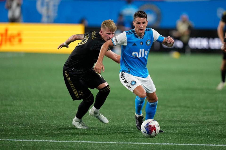 Charlotte FC midfielder Ashley Westwood (8) plays the ball pressured by Los Angeles FC midfielder Mateusz Bogusz (19) in the second half in the second half at Bank of America Stadium.