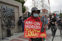 A supporter holds a slogan that reads: "ABS-CBN workers, Fight continues" during a rally outside the ABS-CBN headquarters in Quezon City, Philippines, Friday July 10, 2020. Philippine lawmakers voted Friday to reject the license renewal of the country's largest TV network, shutting down a major news provider that had been repeatedly threatened by the president over its critical coverage. (AP Photo/Aaron Favila)