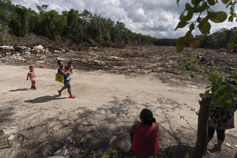 Lidia Caamal Puc se siente en un camino de tierra de la comunidad Vida y Esperanza, en un sector que ha sido despejado para permitir el paso del Tren Maya, en foto del 5 de agosto del 2022. "Pues creo que (el tren) no tiene nada de maya", dice Puc. “Muchos dicen que trae grandes beneficios. Pero nosotros, como mayas que somos, que cultivamos la tierra, que vivimos de aquí, pues no vemos beneficio. Nos están quitando lo que tanto amamos: la tierra en la que trabajamos y que defendemos". (AP Photo/Eduardo Verdugo)