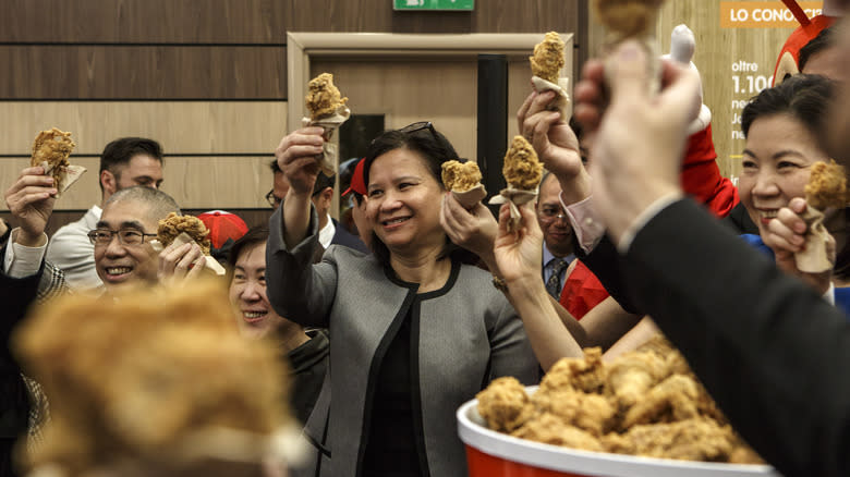 Group of people toasting with fried chicken