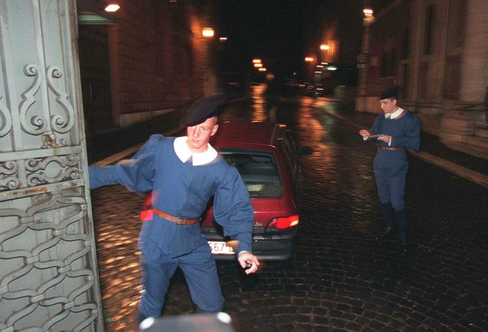 FILE - In this Tuesday, May 5, 1998 file photo, a Swiss Guard shuts St. Anna's gate at the Vatican after letting a car in. The Vatican secretary of state has intervened personally in one of the most sensational Vatican scandals of recent times: The 1998 murder of the Swiss Guard commander and his wife, purportedly by a disgruntled younger Swiss Guardsman who then took his own life. Cardinal Pietro Parolin asked the Vatican City State tribunal to pay “particular attention” to the request by the mother of the accused guardsman, Cedric Tornay, to have access to the court files of the investigation that was officially archived in 1999. (AP Photo/Domenico Stinellis, File)