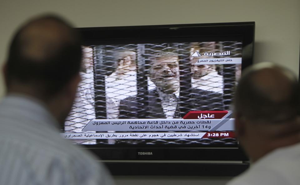 Egyptians watch TV showing the trial of ousted Egyptian president Mohamed Mursi, in Cairo