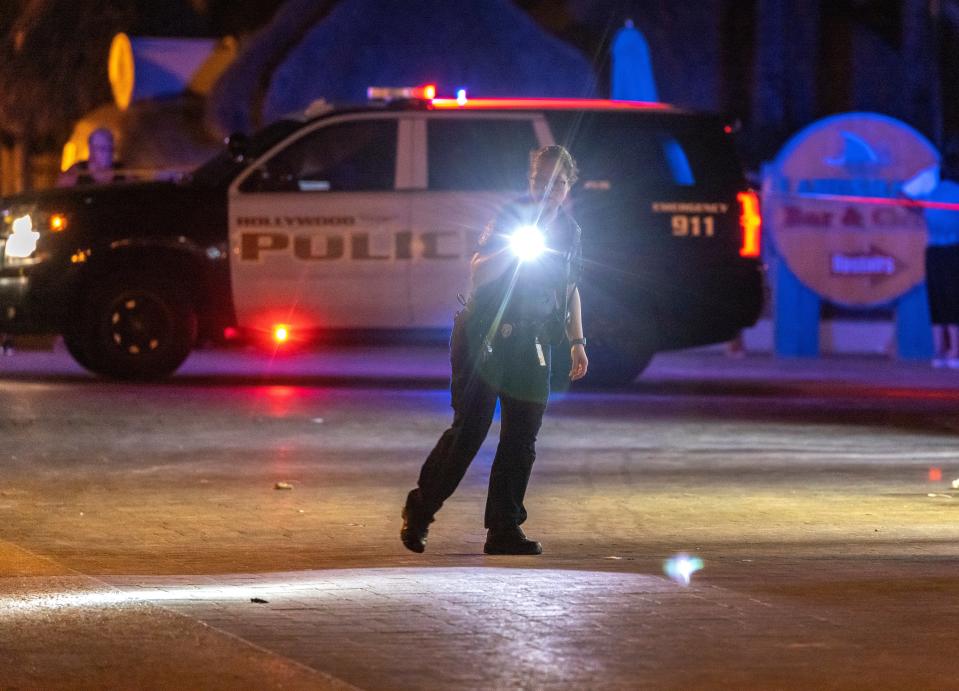 A police officer searches the area where gunfire broke out along a beach boardwalk in Hollywood, Florida, USA, 29 May 2023 (EPA)