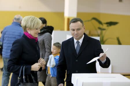 Poland's President Andrzej Duda prepares to cast his ballot next to his wife Agata Kornhauser-Duda at a polling station in Krakow, Poland October 25, 2015. REUTERS/Krzysztof Karolczyk/Agencja Gazeta