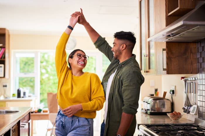 A happy couple dancing in their kitchen