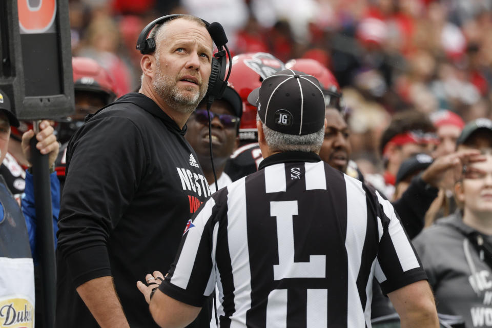North Carolina State head coach Dave Doeren argues a call with line judge Matt Dornan during the first half of the Duke's Mayo Bowl NCAA college football game against Maryland in Charlotte, N.C., Friday, Dec. 30, 2022. (AP Photo/Nell Redmond)