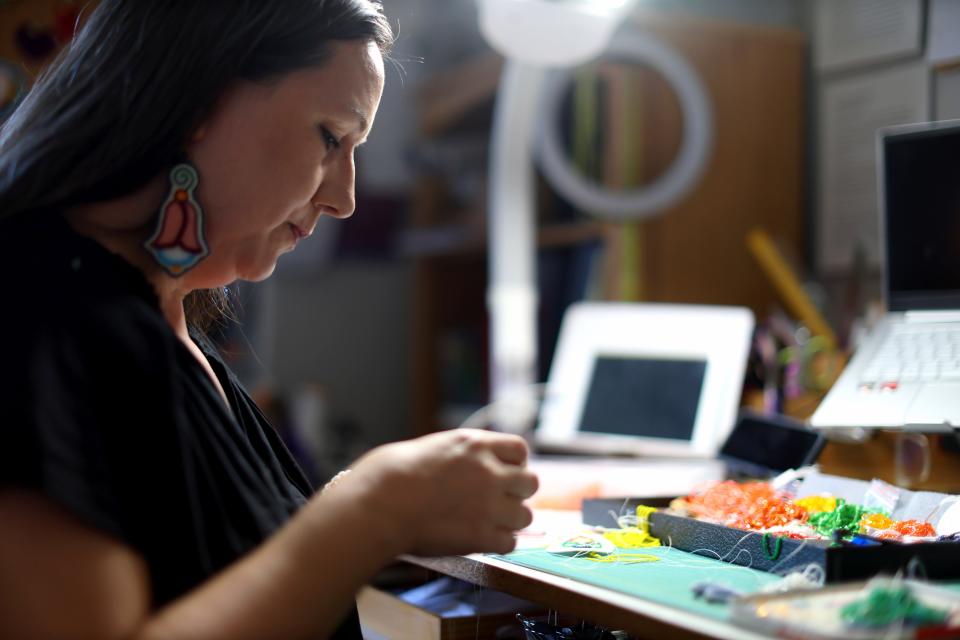 Molly Murphy Adams works on a beaded earring at her home studio in Tulsa, Okla., Sunday, March 3, 2024.