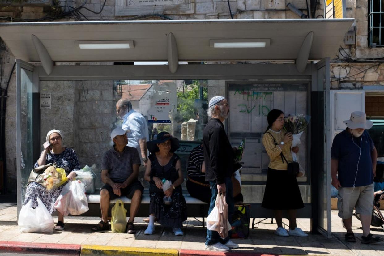 People wait at a bus stop at the Mahane Yehuda market in Jerusalem. <a href="https://www.gettyimages.com/detail/news-photo/people-wait-at-a-bus-stop-at-the-mahane-yehuda-market-on-news-photo/1400881265?phrase=jerusalem%20shop&adppopup=true" rel="nofollow noopener" target="_blank" data-ylk="slk:Alexi Rosenfeld/Getty Images;elm:context_link;itc:0;sec:content-canvas" class="link ">Alexi Rosenfeld/Getty Images</a>