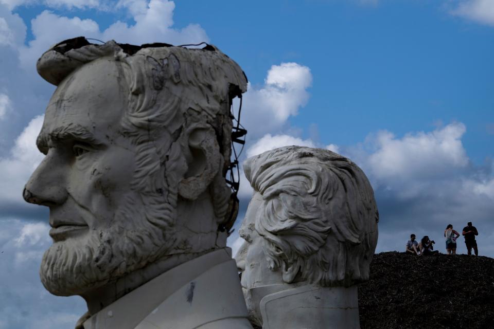 Busts of former US Presidents Abraham Lincoln and Andrew Jackson(R) can be seen as people get an overview from a mountain of mulch while they tour the decaying remains of salvaged busts of former US Presidents August 25, 2019, in Williamsburg, Virginia. (Photo: Brendan Smialowski/AFP/Getty Images)