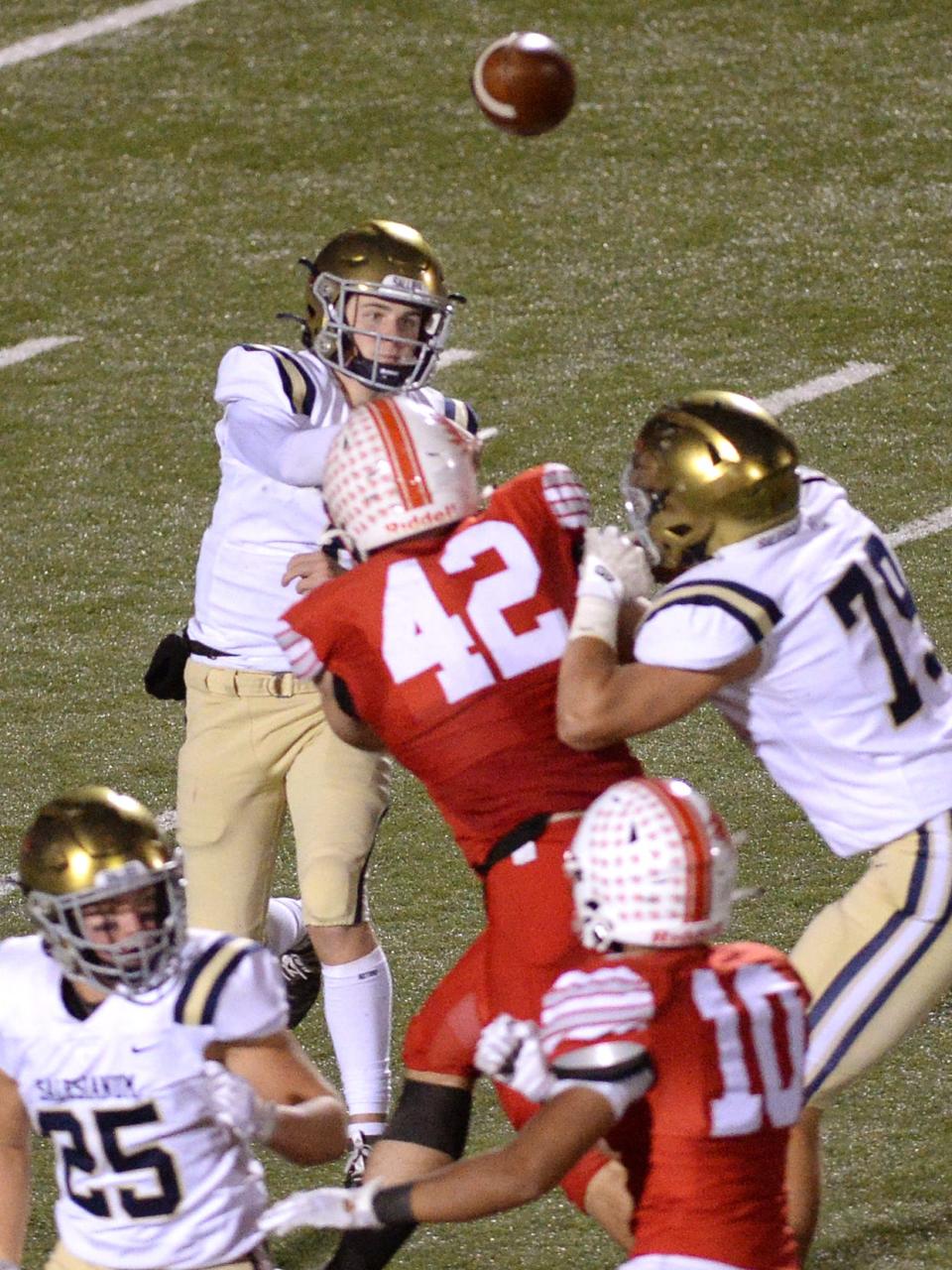 Salesianum quarterback Ryan Stoehr manages to get off a long pass before being hit by Smyrna defender Nate Chandler.