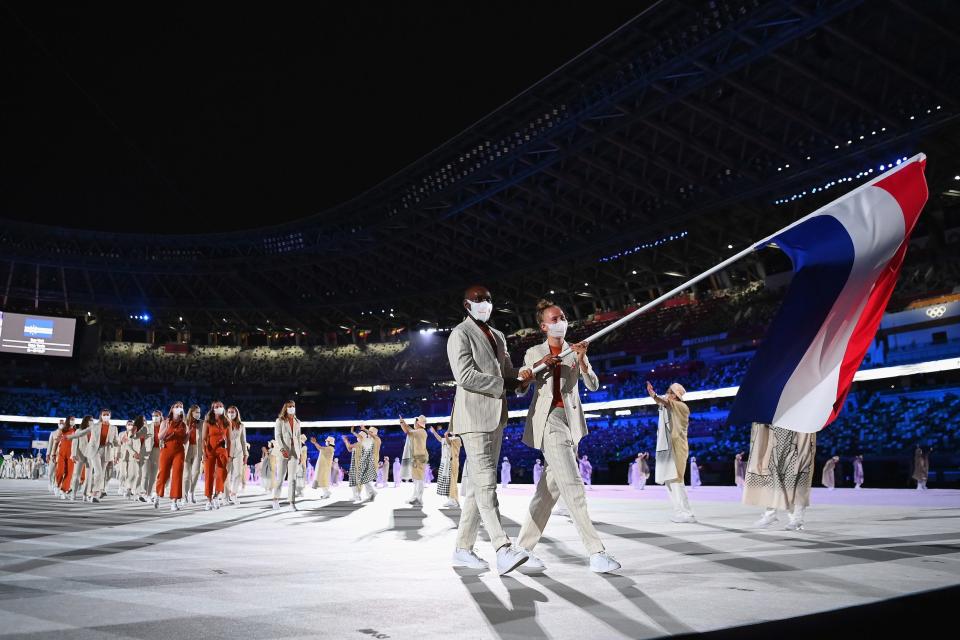 Flag bearers Keet Oldenbeuving and Churandy Martina of Team Netherlands lead their team out during the opening ceremony.