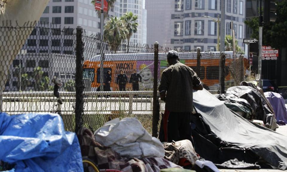 Los Angeles police officers guard a freeway ramp near a newly displaced homeless camp during Donald Trump’s recent visit.