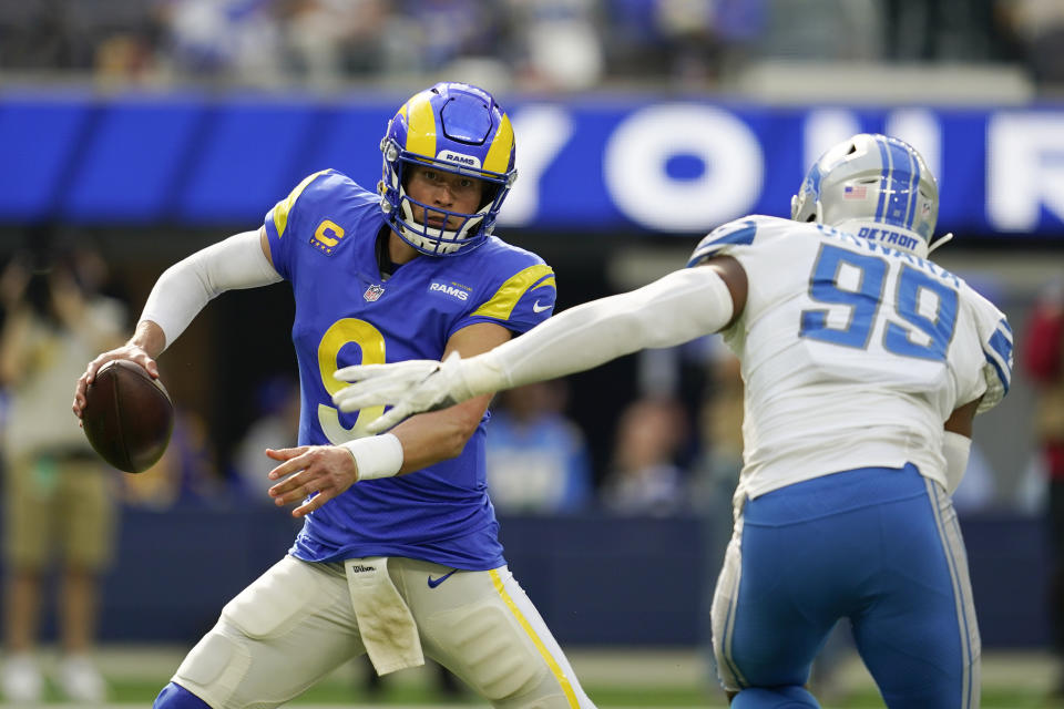 Los Angeles Rams quarterback Matthew Stafford, left, scrambles under pressure from Detroit Lions linebacker Julian Okwara (99) during the second half of an NFL football game Sunday, Oct. 24, 2021, in Inglewood, Calif. (AP Photo/Marcio Jose Sanchez)