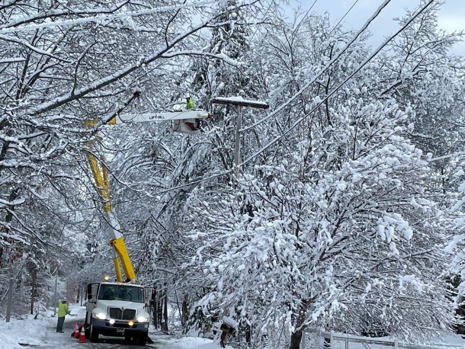 Crews work to restore power Tuesday, Jan. 24, 2023 in South Berwick, Maine, one of many local towns hit hard with power outages in a winter storm.