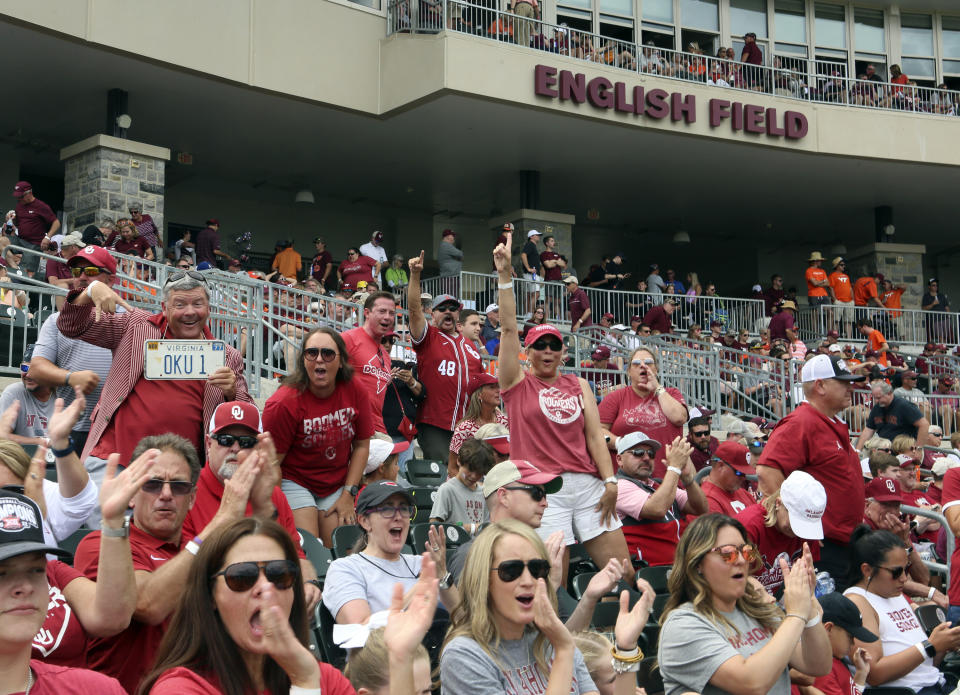 Oklahoma fans celebrate a strikeout to end the third inning against Virginia Tech in an NCAA college baseball tournament super regional game Friday, June 10, 2022, in Blacksburg, Va. (AP Photo/Matt Gentry)