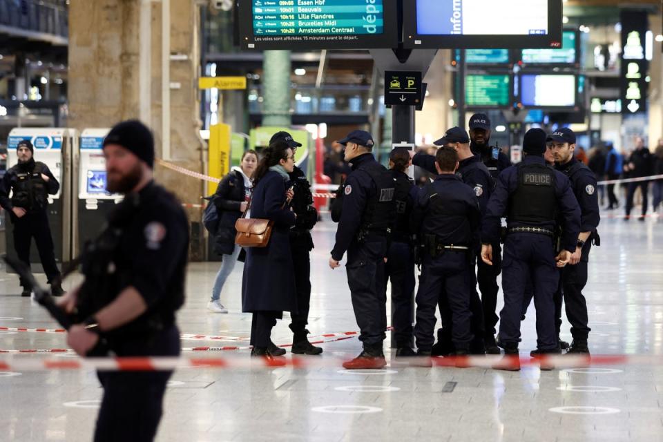 Concerned travellers speak to armed police in the train station (REUTERS)