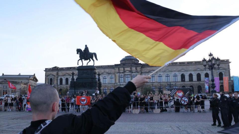 A man holds a German flag during a protest in Dresden