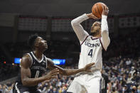 Connecticut's Tyrese Martin shoots as Georgetown's Aminu Mohammed (0) defends in the second half of an NCAA college basketball game, Tuesday, Jan. 25, 2022, in Storrs, Conn. (AP Photo/Jessica Hill)