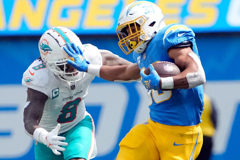 Los Angeles Chargers running back Austin Ekeler (30) stiff-arms Miami Dolphins safety Jevon Holland (8) during the first half of an NFL football game Sunday, Sept. 10, 2023, in Inglewood, Calif. (AP Photo/Mark J. Terrill)