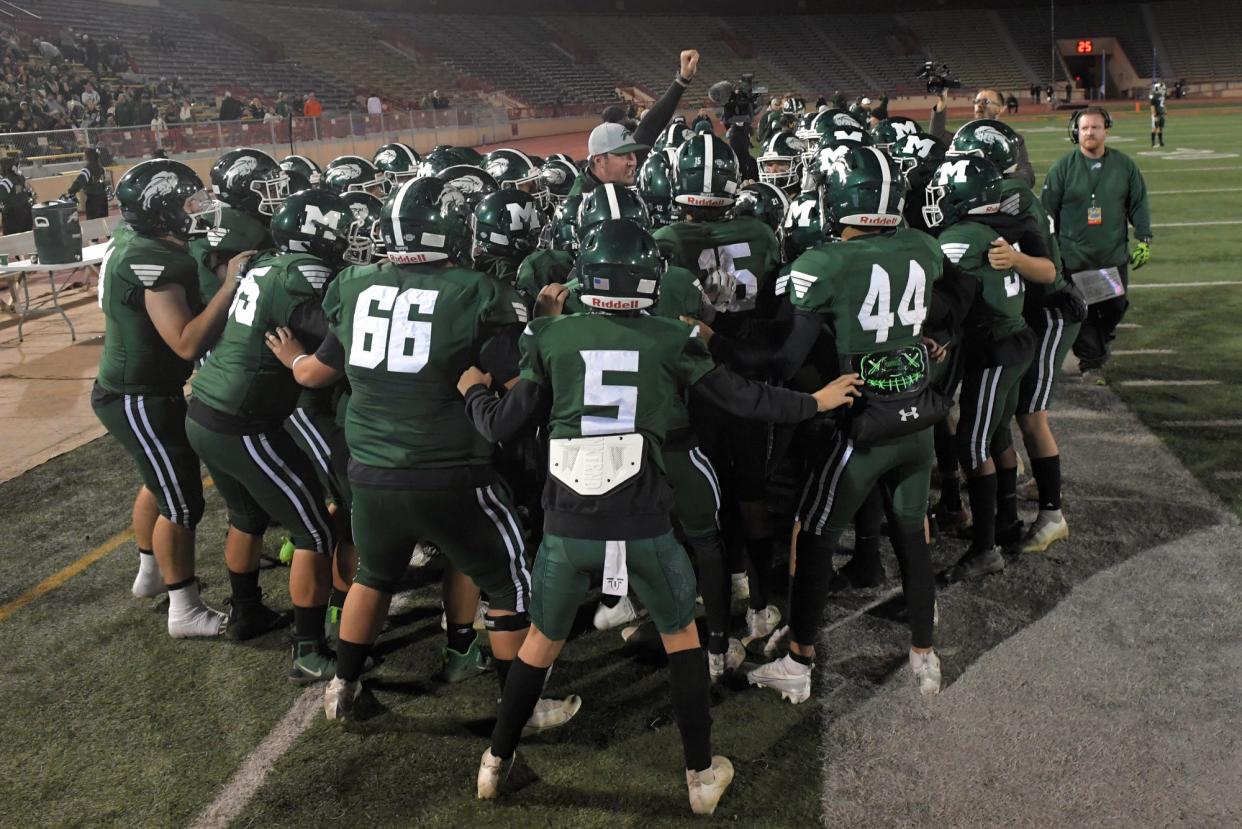 The Manteca varsity football team gathers in a huddle before the start of the CIF Sac-Joaquin Section Division II football championship game against Granite Bay at Hughes Stadium in Sacramento on Saturday, Nov. 26, 2022. 