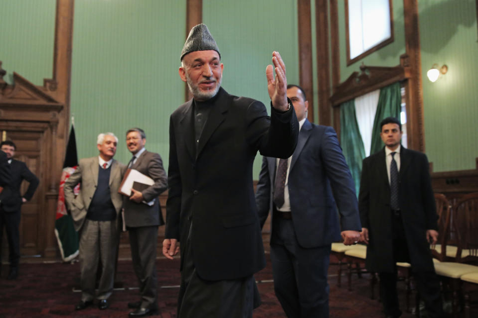 Afghan President Hamid Karzai greets journalists as he leaves a press conference at the presidential palace in Kabul, Afghanistan, Saturday, Jan. 25, 2014. Karzai said he will not sign a security pact with the United States unless Washington and Pakistan launch a peace process with Taliban insurgents. (AP Photo/Massoud Hossaini)