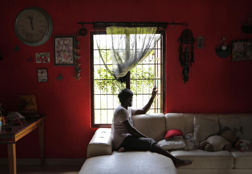 Sri Lankan auto rickshaw driver Prasad Dinesh, linked by Sri Lankan officials to nearly half the country's more than 2,600 coronavirus cases, sits in his house in Ja-Ela, Sri Lanka, Wednesday, July 1, 2020. For months he’s been anonymous, but now Dinesh is trying to clear his name and shed some of the stigma of a heroin addiction at the root of his ordeal. Referring to him only as “Patient 206,” government officials lambasted Dinesh on TV and social media, blaming him for at least three clusters of cases, including about 900 navy sailors who were infected after an operation in Ja-Ela, a small town about 19 kilometers (12 miles) north of the capital, Colombo. Dinesh, however, says his drug addiction, which is considered a crime in Sri Lanka, makes him a convenient scapegoat. (AP Photo/Eranga Jayawardena)