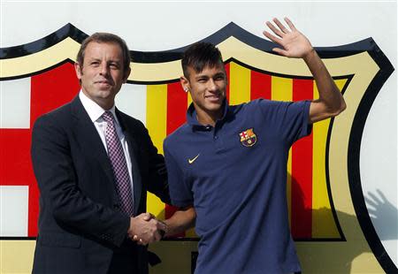 Brazilian soccer player Neymar (R) shakes hands with Barcelona's president Sandor Rosell after signing a five-year contract with FC Barcelona, in front of their offices close to Camp Nou stadium in Barcelona in this June 3, 2013 file photo. REUTERS/Albert Gea