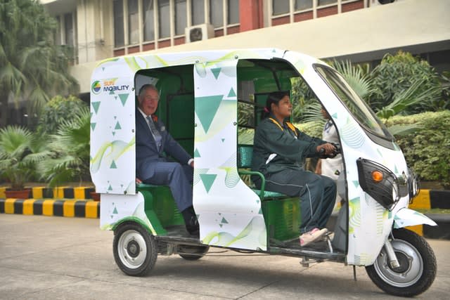 The Prince of Wales is given a demonstration of an e-rickshaw at the Indian MET office in New Delhi